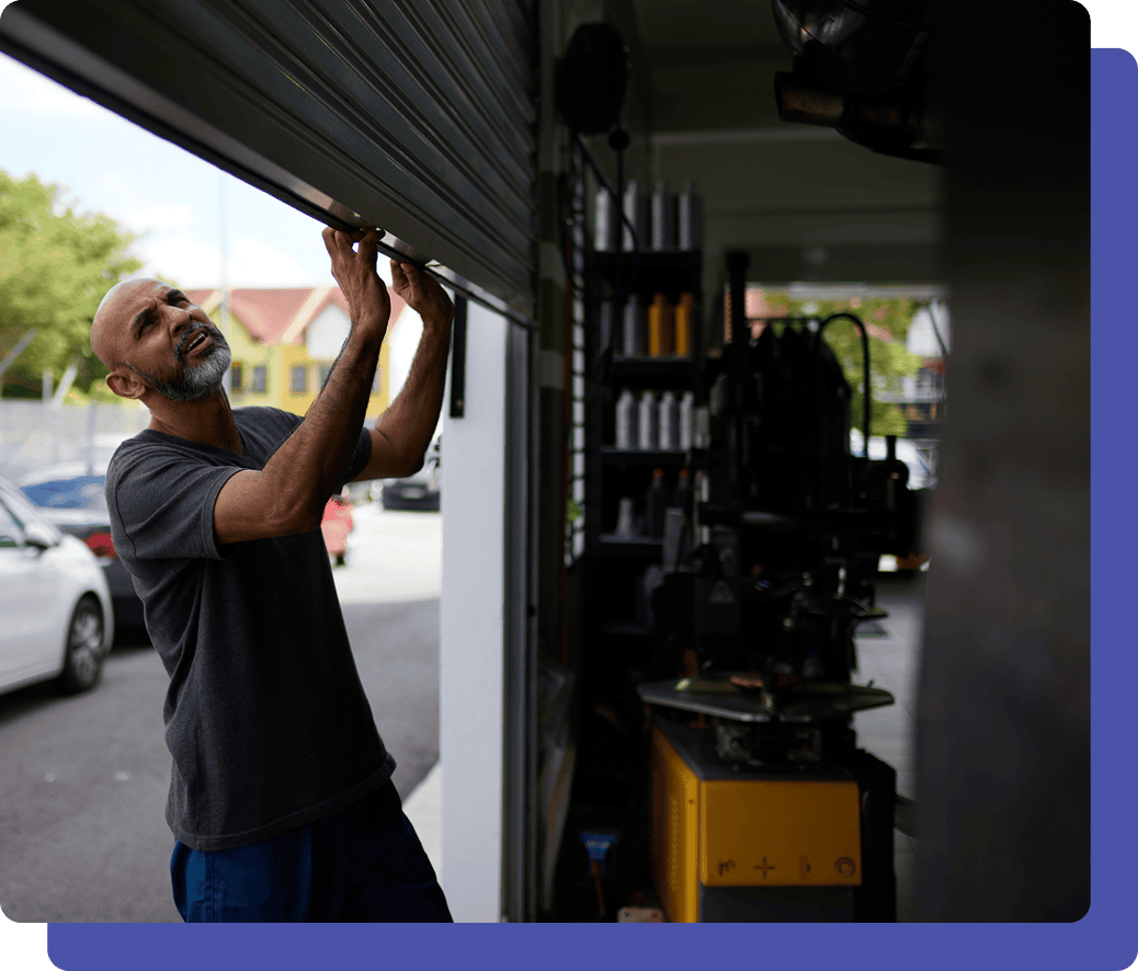 Man opening garage door, sunny day.