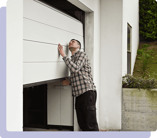 Man inspecting partially open garage door.